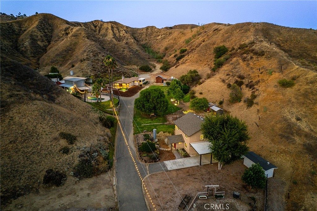 Twilight aerial view of the 7.7-acre canyon compound showing both residences and outbuildings